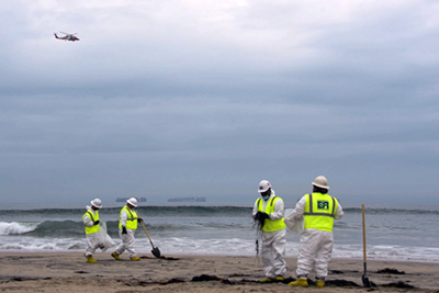 Contractors remove oil and debris along the shoreline